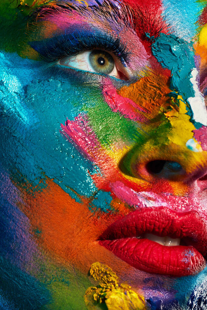 The greatest masterpieces were once only pigments on a palette. Studio shot of a young woman posing with multi-coloured paint on her face - Photo, image