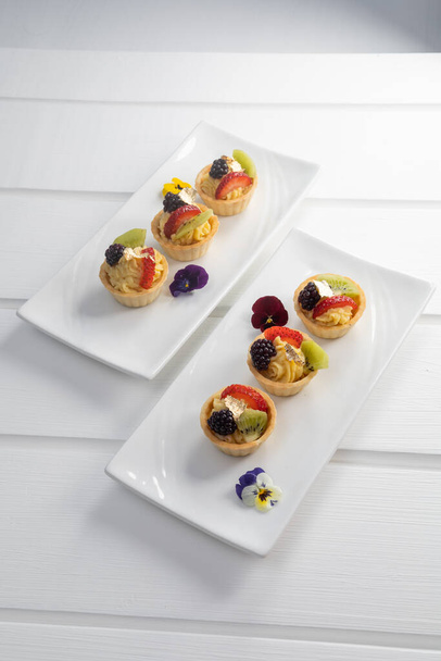 вкусные закуски на тарелках, изысканные блюда, украшенные фруктами, сладкие обои для десерта, выпечка - Фото, изображение