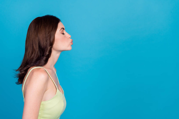 Profile portrait of cute gorgeous girl closed eyes pouted lips kiss empty space isolated on blue color background. - 写真・画像