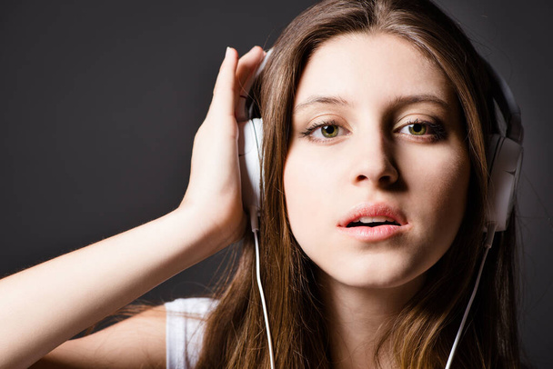 Easy to wear, easy to hear. a young woman listening to music against a studio background - Foto, Imagem