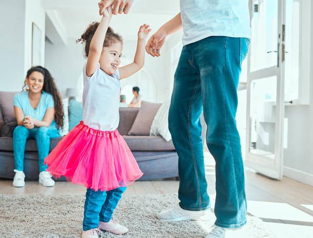 Мои отцы готовы ко всему. маленькая девочка танцует со своим отцом, пока ее мать отдыхает на диване дома - Фото, изображение