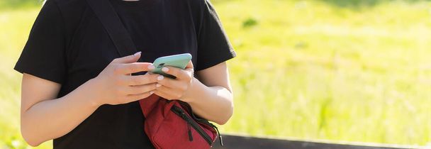 公園でスマートフォンを使う若い女性 - 写真・画像