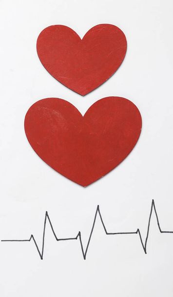 Línea de frecuencia cardíaca con corazones sobre fondo blanco. Concepto de corazón saludable - Foto, imagen