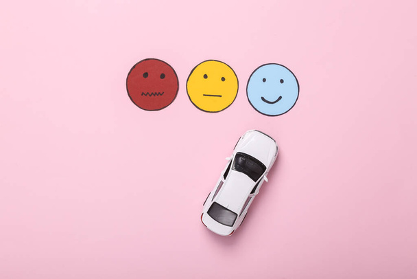 物流、タクシーや車の共有サービス。顧客満足度調査の概念。おもちゃの車の選択ピンクの背景に幸せな顔のアイコン、中性と悲しい顔の紙のアイコン。トップ表示 - 写真・画像