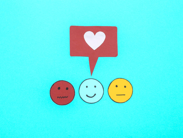 Umfrage zur Kundenzufriedenheit. Glückliches, neutrales und trauriges Gesichtspapier-Symbol mit ähnlichem Symbol auf blauem Hintergrund. Ansicht von oben - Foto, Bild