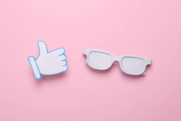 Óculos com polegares para cima ícones no fundo rosa. Avaliação, feedback dos seguidores. Vista superior - Foto, Imagem