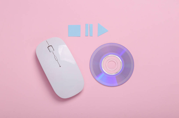 PC ratón con el disco cd y los iconos de inicio, parada, pausa del reproductor multimedia sobre fondo rosa. Vista superior - Foto, imagen