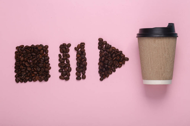 Koffiebonen in de vorm van start, stop, pauze pictogrammen van mediaspeler en koffiekop op roze achtergrond. Bovenaanzicht - Foto, afbeelding
