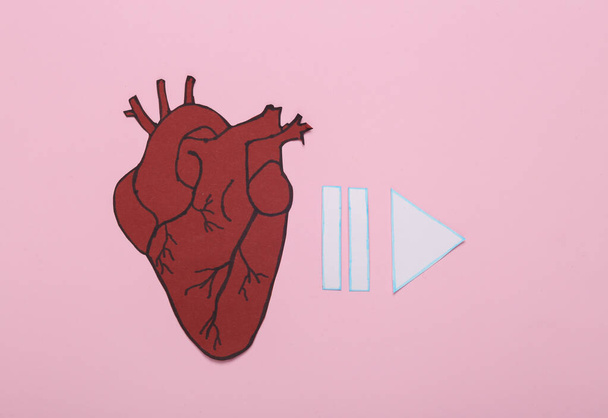 Επανεκκίνηση καρδιάς. Χαρτοκαρδιά με εικονίδια ξεκινήσει, παύση σε ροζ φόντο. Άνω όψη - Φωτογραφία, εικόνα