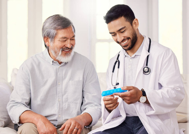 Si sigues esta rutina, definitivamente te sentirás mejor. un médico sosteniendo una caja de pastillas mientras habla con un paciente mayor - Foto, imagen