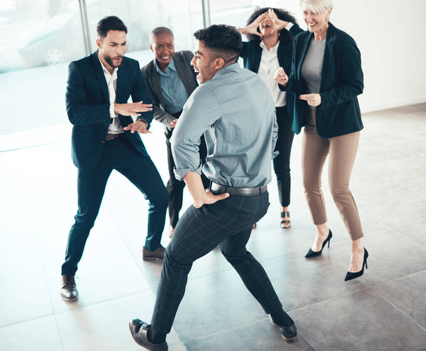 Were a team who know how to have fun too. Full length shot of a diverse group of businesspeople dancing in the office - Фото, изображение