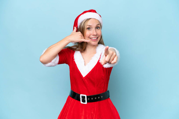 Young blonde woman dressed as mama claus isolated on blue background making phone gesture and pointing front - Zdjęcie, obraz