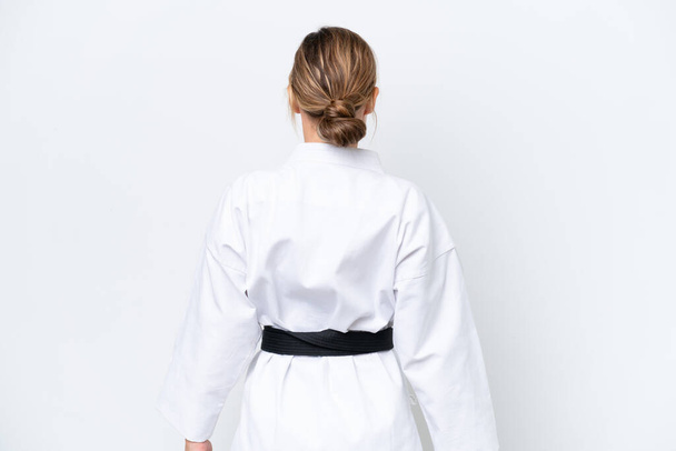 Giovane donna caucasica isolata su sfondo bianco facendo karate in posizione posteriore - Foto, immagini