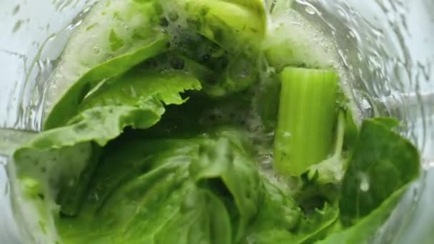 Szekrény zöldek keverése elektromos mixer szuper lassított felvételen. Top view nyers kelkáposzta petrezselyem zeller keverés turmixgép az egészséges vitamin koktél. Egészséges vegetáriánus zöldség elkészítése. - Felvétel, videó