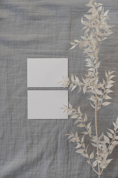 Tarjeta de papel en blanco con espacio de copia maqueta, elegante tallo de hierba seca en tela de lino gris. Vista superior, plantilla de marca estética minimalista laico plano - Foto, imagen