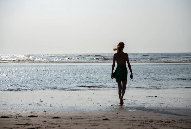 jong meisje permanent op het strand - Foto, afbeelding
