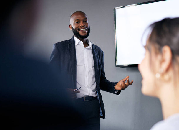 Η ομαδική δουλειά ξεκινά με την οικοδόμηση εμπιστοσύνης. ένας νεαρός επιχειρηματίας που δίνει μια παρουσίαση κατά τη διάρκεια μιας συνάντησης στην αίθουσα συνεδριάσεων - Φωτογραφία, εικόνα