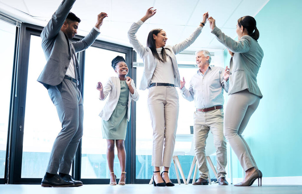 Czas na imprezę. Pełne ujęcie zróżnicowanej grupy biznesmenów korporacyjnych tańczących w swoim biurze na imprezie firmowej - Zdjęcie, obraz