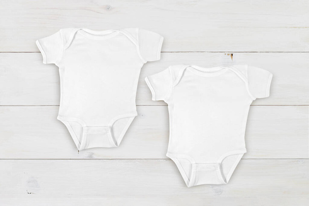 Primer plano de dos bebés blancos que descansan sobre un moderno fondo de madera blanca. - Foto, imagen