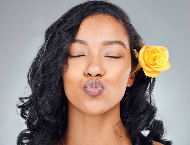New hair, who this. Studio shot of an attractive young woman pouting with a yellow flower in her hair against a grey background - Zdjęcie, obraz