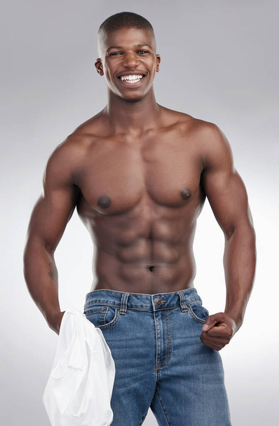 The shirt or no shirt. a handsome young man standing alone in the studio and posing shirtless - Fotó, kép