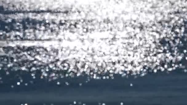 Fondo borroso abstracto.Macetas de reflejos blancos de sol brillante en la superficie azul de las ondas del mar.Mar en el día soleado.Fondo borroso natural de la textura del bokeh.Lazo sin costura.Fondo natural hermoso - Imágenes, Vídeo