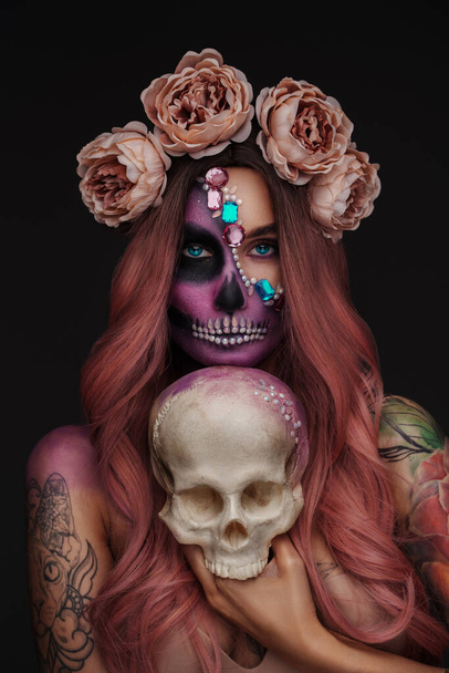 Retrato de mujer malvada glamour en estilo halloween con corona de rosas y cráneo. - Foto, Imagen