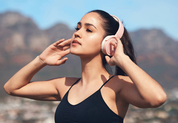 Megfelelő hangulatot teremteni. egy fiatal nő zenét hallgat edzés közben - Fotó, kép