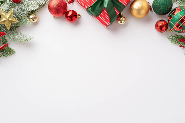 Weihnachtskonzept. Foto von oben von rot grünen und goldenen Kugeln Stern Ornament Geschenkbox mit Schleife Schleife Mistelbeeren und Kiefernzweig im Schnee auf isoliertem weißem Hintergrund mit leeren Raum - Foto, Bild