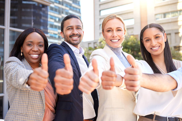 Weve got what it takes to help you succeed. a group of businesspeople showing a thumbs up against a city background - Foto, imagen
