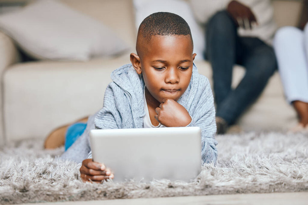 Neues lernen. ein kleiner Junge, der zu Hause ein digitales Tablet benutzt - Foto, Bild