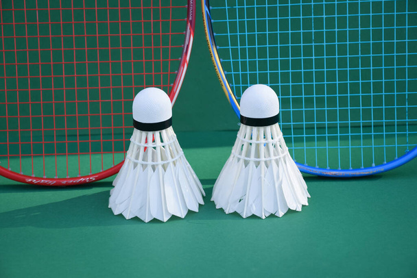 Beyaz badminton topu ve raketi kapalı badminton kortunda, kopyalama alanı, mekik horozlarına yumuşak ve seçici odaklanma. - Fotoğraf, Görsel