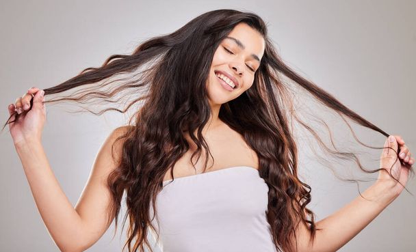 Suelta el pelo y diviértete. Foto de estudio de una mujer joven con hermoso cabello largo - Foto, imagen