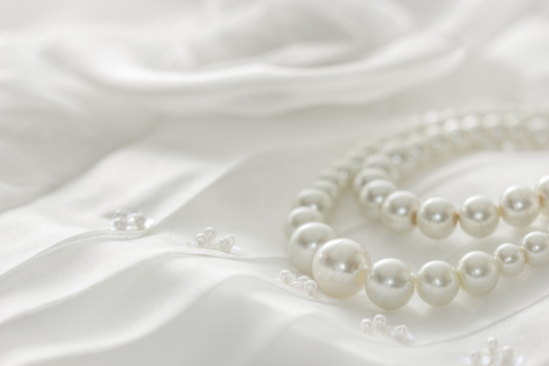 Perlenkette auf Spitzenhintergrund, ausgewählter Fokus. - Foto, Bild