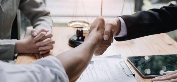 Gros plan de la main d'avocate et de l'homme client serrant la main collaborent à des accords de travail avec des documents contractuels au bureau.. - Photo, image