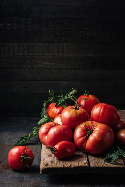 Freshly picked ripe red organic tomatoes on a dark background. - Photo, Image