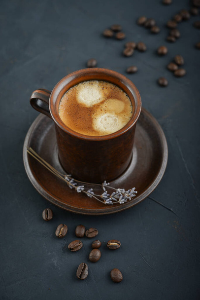 Kopje koffie met koffiebonen op zwarte achtergrond, bovenaanzicht  - Foto, afbeelding