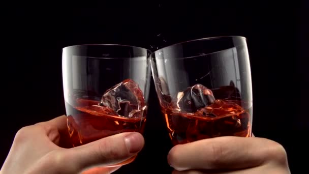Two glasses of whiskey toasting - Felvétel, videó