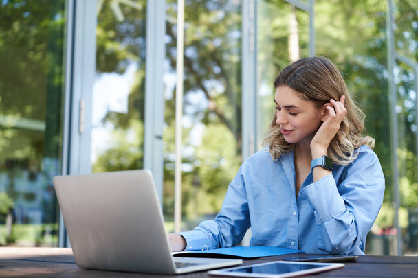 Retrato de mujer corporativa con laptop, trabajando en proyecto, usando computadora al aire libre. Joven estudiante haciendo tareas al aire libre al aire libre. - Foto, imagen