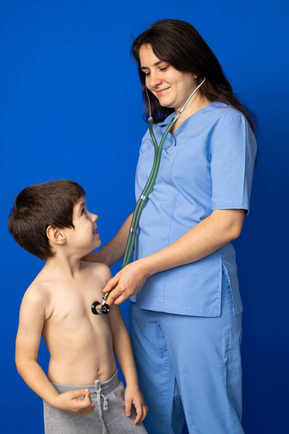 Врач слушает сердце и легкие 5-летнего мальчика со стетоскопом - Фото, изображение