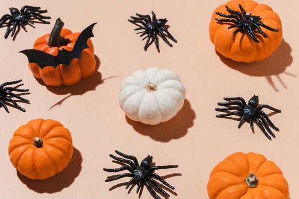 Halloween pattern with trendy hard shadows. Orange pumpkins and black spiders pattern on pastel background. Decoration for Halloween party. Copy space, blogs, promotions - Foto, immagini