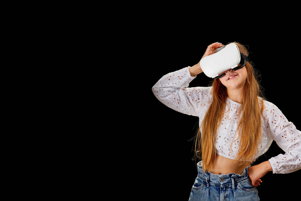 Young woman wearing VR glasses and interacting with virtual reality, entertainment, education and innovative technology concept. goggles to interact with metaverse - Zdjęcie, obraz