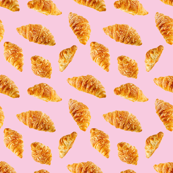 seamless pattern made from Fresh croissant isolated on pink background. Bakery pattern with baked croissant with cheese. - 写真・画像