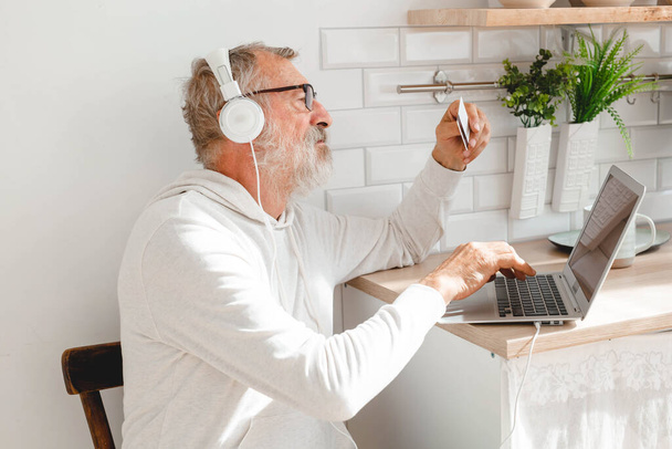 Старший чоловік в ноутбуці, що платить кредитною карткою за онлайн-покупки
 - Фото, зображення
