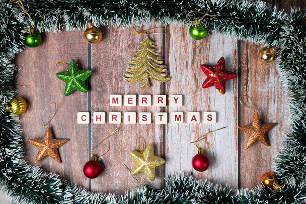 Веселого Рождества, написанного буквами игры и рождественскими украшениями на деревянном фоне - Фото, изображение