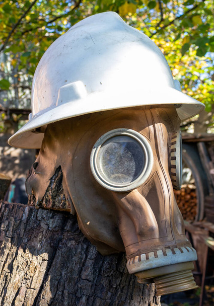 Een oud gasmasker met een witte helm. - Foto, afbeelding