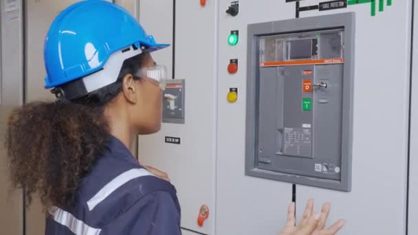 Электрическая молодая азиатская женщина-инженер осматривает систему шкафа технического обслуживания электрической и с использованием планшета в диспетчерской на промышленном заводе, техник или электрик контроля распределения энергии. - Кадры, видео