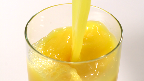 Χύοντας χυμό πορτοκαλιού σε ποτήρι - Πλάνα, βίντεο