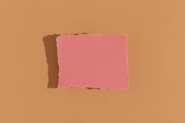 Cartão de saudação rosa em um fundo bege. Luz dura, vista superior. - Foto, Imagem