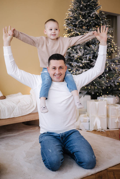 Happy father with his son playing home during winter holidays. Christmas is coming - 写真・画像